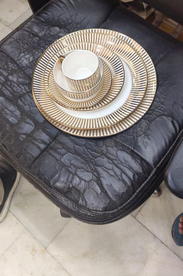 Gold striped dinner plate, side plate, cup and bowl stacked together